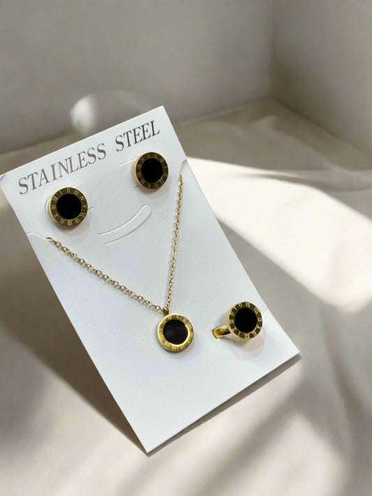 Gold necklace and earrings on a 'Stainless Steel' card held by a hand.